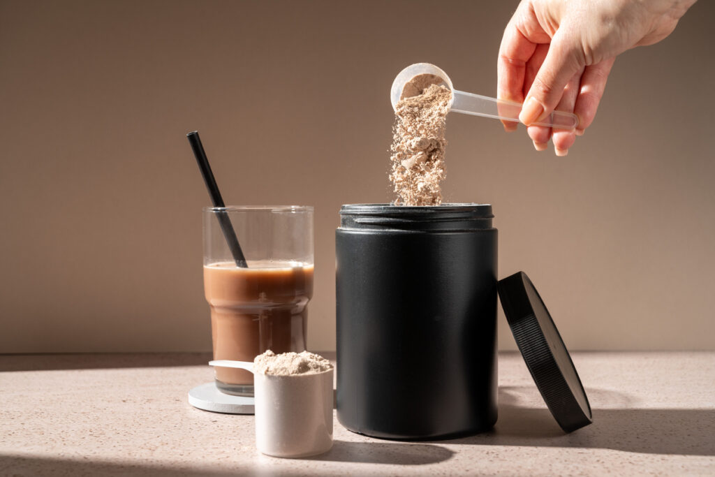Protein shake and chocolate protein powder in a scoop, food supplement